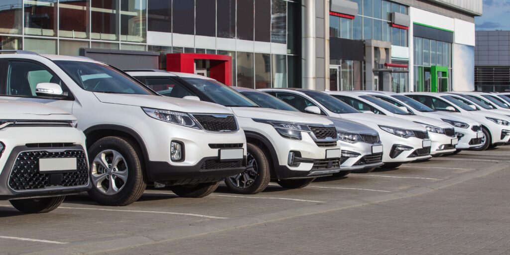 Cars parked in front of a dealership; auction vehicle transport in Canada.