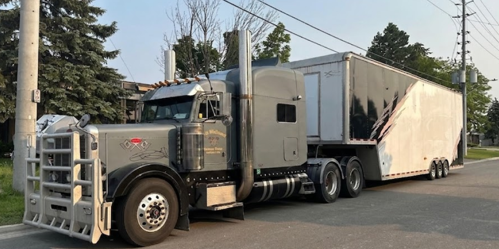 Enclosed car shipping trailer transporting luxury cars.